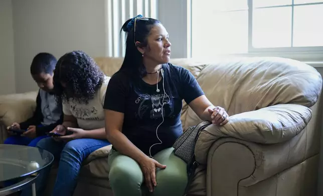 María Ángel Torres talks during an interview at her apartment as her daughter Alisson Ramírez and grandson Dylan Martínez play on their phones Friday, May 18, 2024, in Aurora, Colorado. (AP Photo/Jack Dempsey)