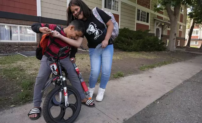 Alisson, right, plays with her nephew Dylan outside their apartment Thursday, Aug. 29, 2024, in Aurora, Colo. (AP Photo/Godofredo A. Vásquez)