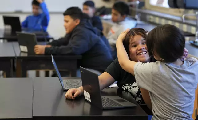 Alisson Ramírez, second from right, plays with a classmate during science class Wednesday, Aug. 28, 2024, in Aurora, Colo. (AP Photo/Godofredo A. Vásquez)