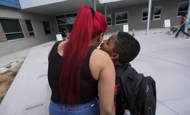 Dylan Martínez-Ramírez, right, kisses his mother goodbye while being dropped off at school Thursday, Aug. 29, 2024, in Aurora, Colo. (AP Photo/Godofredo A. Vásquez)