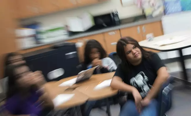 Alisson Ramírez, right, listens to her social studies teacher during class Wednesday, Aug. 28, 2024, in Aurora, Colo. (AP Photo/Godofredo A. Vásquez)