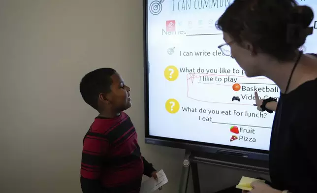 Dylan Martínez-Ramírez, left, sounds out a sentence as instructed by Culturally &amp; Linguistically Diverse Education teacher Sarah Pearlstein at Del Mar Academy, Thursday, Aug. 29, 2024, in Aurora, Colo. (AP Photo/Godofredo A. Vásquez)