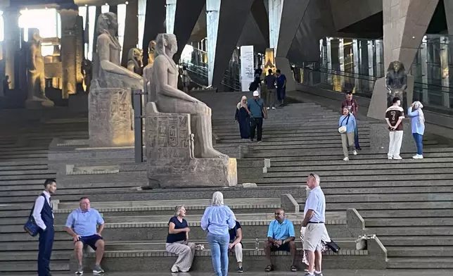 Visitors walk past ancient Egyptian colossal statues along the Grand Staircase at the Grand Egyptian Museum in Giza, Egypt, Tuesday, Oct.15, 2024. (AP Photo/Khaled Elfiqi)