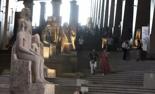 Visitors walk past ancient Egyptian colossal statues along the Grand Staircase at the Grand Egyptian Museum in Giza, Egypt, Tuesday, Oct.15, 2024. (AP Photo/Khaled Elfiqi)