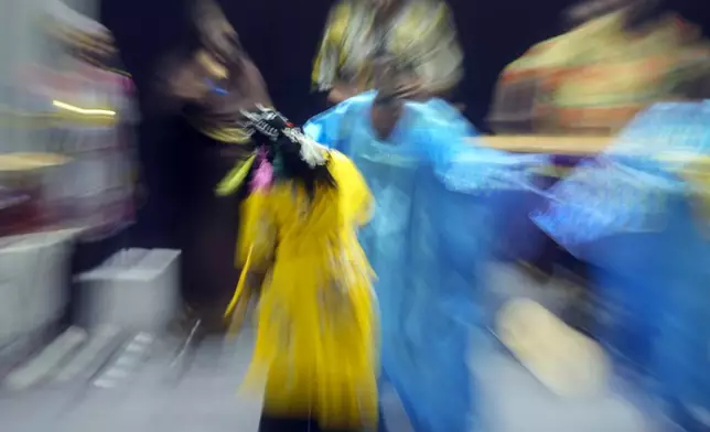 In this image taken with a slow shutter speed, Sudanese Camirata troupe dancers perform a "Al Hamal Rakd" dance from West Sudan, during a show at the Russian culture center in Cairo, Egypt, Sunday, Sept. 15, 2024. (AP Photo/Amr Nabil)