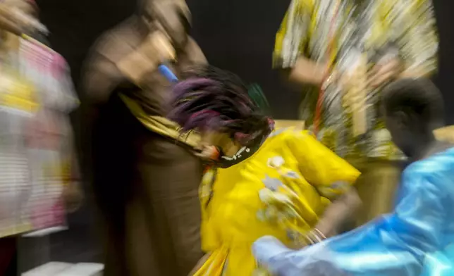 In this image taken with a slow shutter speed, Sudanese Camirata troupe dancers perform a "Al Hamal Rakd" dance from West Sudan, during a show at the Russian culture center in Cairo, Egypt, Sunday, Sept. 15, 2024. (AP Photo/Amr Nabil)