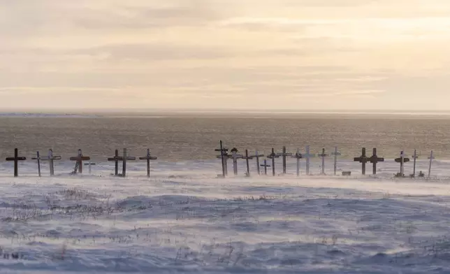 Wind blows snow along the surface of the village cemetery looking towards the Kaktovik Lagoon and the coastal plain of the Arctic National Wildlife Refuge, in Kaktovik, Alaska, Monday, Oct. 14, 2024. (AP Photo/Lindsey Wasson)