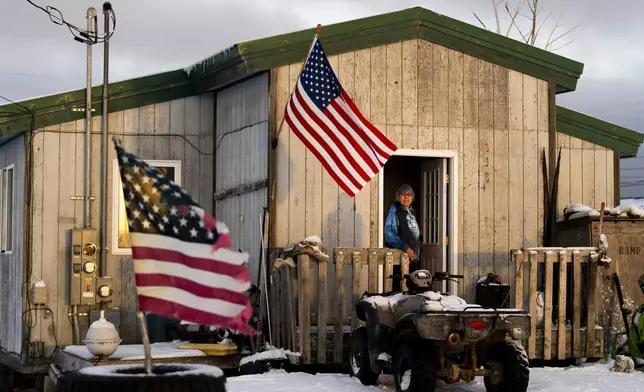 Alice Aishanna poses for a portrait outside her home displaying several American flags in Kaktovik, Alaska, Tuesday, Oct. 15, 2024. (AP Photo/Lindsey Wasson)