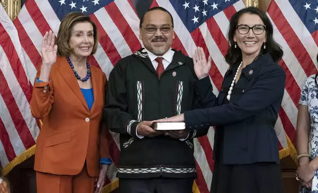 FILE - Speaker of the House Nancy Pelosi of Calif., left, administers the House oath of office to Rep. Mary Peltola, D-Alaska, accompanied by her husband Eugene "Buzzy" Peltola Jr., center, during a ceremonial swearing-in on Capitol Hill in Washington, Tuesday, Sept. 13, 2022. (AP Photo/Jose Luis Magana, File)