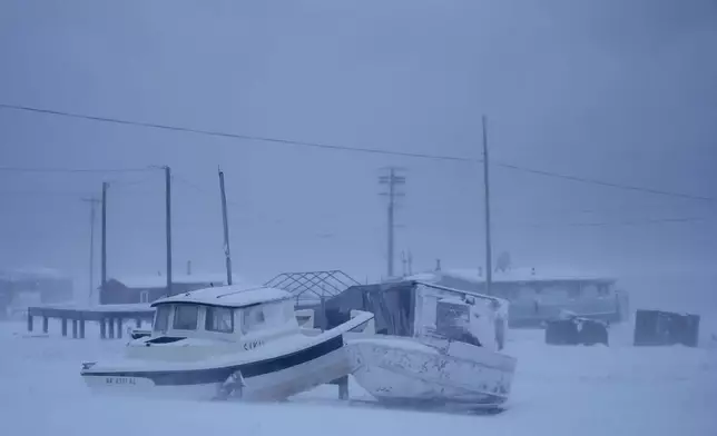 A pair of small boats sit in a blizzard in Kaktovik, Alaska, Thursday, Oct. 17, 2024. (AP Photo/Lindsey Wasson)