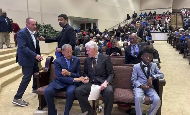 Former President Bill Clinton and US Rep. Sanford Bishop talk while seated at Mt. Zion Baptist Church in Albany, Ga. on Sunday, Oct. 13, 2024. (AP Photo/Charlotte Kramon)