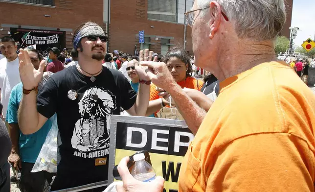 FILE - Nineteen year old Cuaghtlatohuac Haitzilopoch, left, has a heated conversation with a supporter of the new immigration-enforcement law during a protest of Arizona's SB1070 in front of Maricopa County Sheriff Joe Arpaio's office, July 29, 2010 in Phoenix. (AP Photo/Ralph Freso, File)