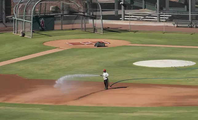 A grounds crew worker waters one of the baseball fields at the Los Angeles Angels training complex Tuesday, Sept. 24, 2024, in Tempe, Ariz. (AP Photo/Ross D. Franklin)