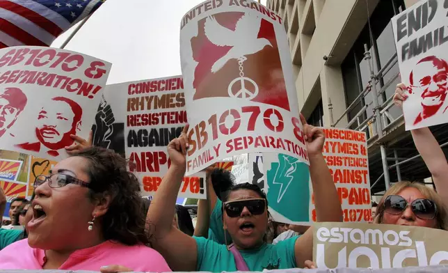 FILE - Protesters march against Arizona's illegal immigration law, SB1070, April 25, 2012, in Phoenix. (AP Photo/Matt York, File)