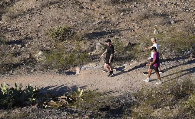 Hikers walk a trail near "A" Mountain Tuesday, Sept. 24, 2024, in Tempe, Ariz. (AP Photo/Ross D. Franklin)