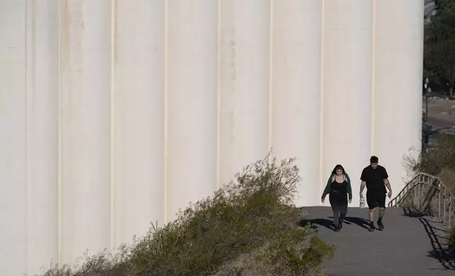 Hikers walk past the Hayden Flour Mill on thier way up "A" Mountain Tuesday, Sept. 24, 2024, in Tempe, Ariz. (AP Photo/Ross D. Franklin)