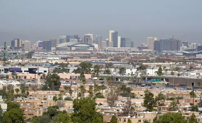 Condos and apartments give way to the Phoenix skyline Tuesday, Sept. 24, 2024, in Tempe, Ariz. (AP Photo/Ross D. Franklin)