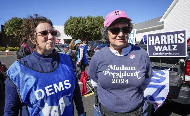 Supporters for Vice President Kamala Harris, Juliette Delgado, left, and Toni Mangan, both of Rutherford County, outside the Rutherford County Annex Building, where early voting was taking place, Thursday, Oct. 17, 2024 in Rutherfordton, N.C. (AP Photo/Kathy Kmonicek)