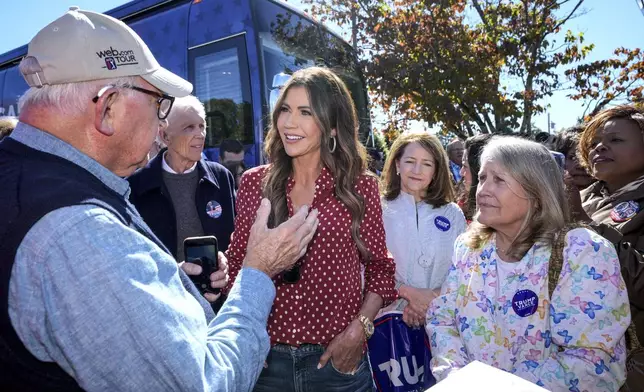 Governor Kristi Noel (SD), third from left, talks with Trump supporter, Tom Dodgen of Rutherfordton, left, at the Team Trump bus tour across North Carolina, Thursday, Oct. 17, 2024 in Rutherfordton, N.C. (AP Photo/Kathy Kmonicek)