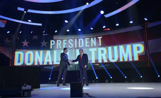 FILE - Former President Donald Trump, right, shakes hands with Turning Point CEO Charlie Kirk before speaking during the Turning Point USA Student Action Summit, Saturday, July 23, 2022, in Tampa, Fla. (AP Photo/Phelan M. Ebenhack, File)