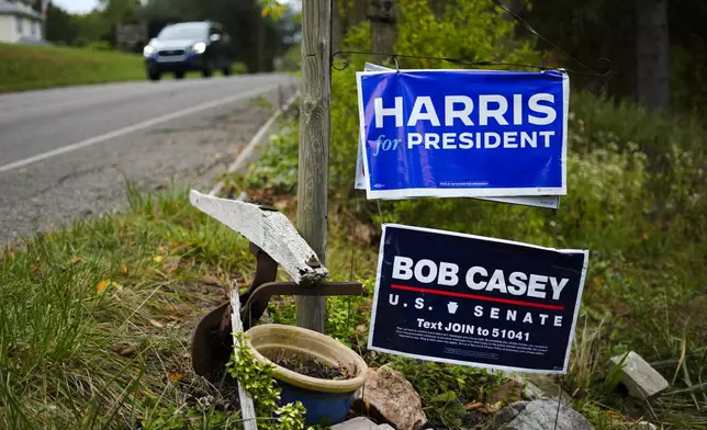 A car passes signs supporting Democratic presidential nominee Vice President Kamala Harris and Sen. Bob Casey, D-Pa., in Butler, Friday, Sept. 27, 2024. (AP Photo/Matt Rourke)