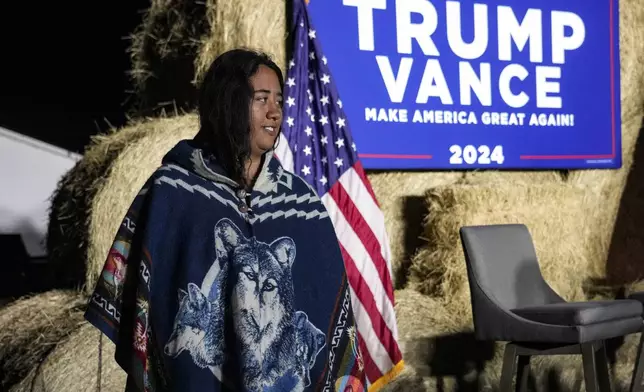 A Native American woman walks by the stage during a campaign event in support of Republican presidential nominee former President Donald Trump, Friday, Oct. 18, 2024, in Red Springs, N.C. (AP Photo/David Yeazell)