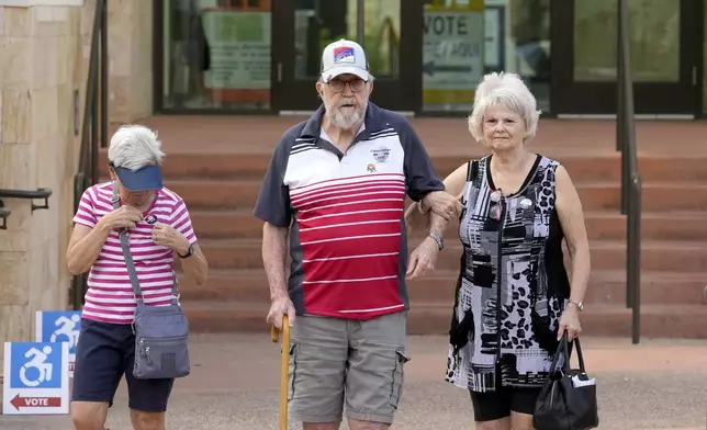 Voters leave Surprise City Hall after voting on the first day of early in-person voting for the general election Wednesday, Oct. 9, 2024, in Surprise, Ariz. (AP Photo/Ross D. Franklin)