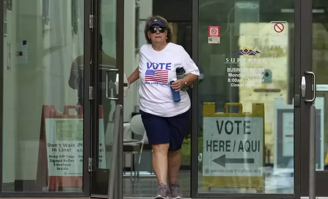 A voter leaves Surprise City Hall after voting on the first day of early in-person voting for the general election Wednesday, Oct. 9, 2024, in Surprise, Ariz. (AP Photo/Ross D. Franklin)