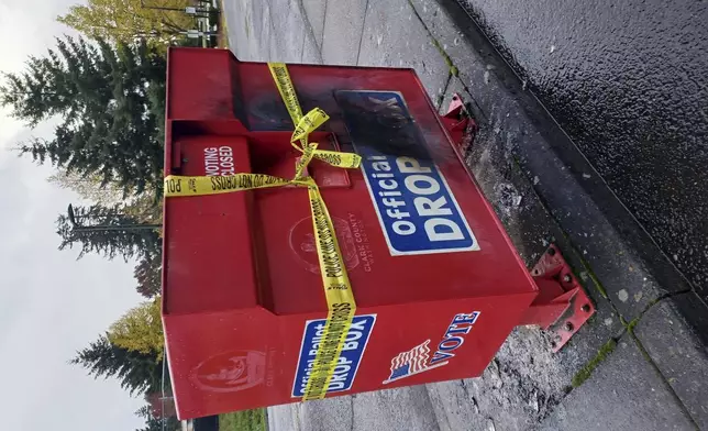 Police tape surrounds a ballot drop box damaged by a fire on Monday, Oct. 28, 2024, in Vancouver, Wash. (Monika Spykerman/The Columbian via AP)