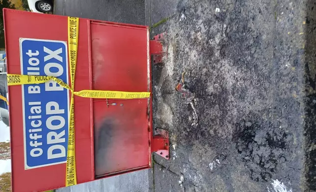 Police tape surrounds a ballot drop box damaged by a fire on Monday, Oct. 28, 2024, in Vancouver, Wash. (Monika Spykerman/The Columbian via AP)