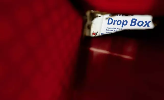 A fire-damaged ballot drop box bin is seen next to the drop box during a news conference at the Multnomah County Elections Division office on Monday, Oct. 28, 2024, in Portland, Ore. (AP Photo/Jenny Kane)