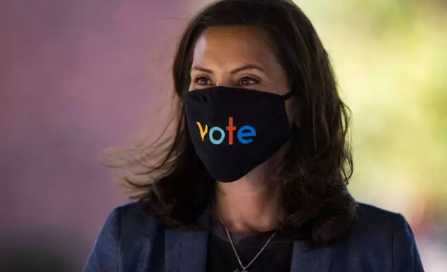 FILE - Michigan Gov. Gretchen Whitmer wears a mask with the word "vote" displayed on the front during a roundtable discussion on healthcare, Oct. 7, 2020, in Kalamazoo, Mich. (Nicole Hester=miarb