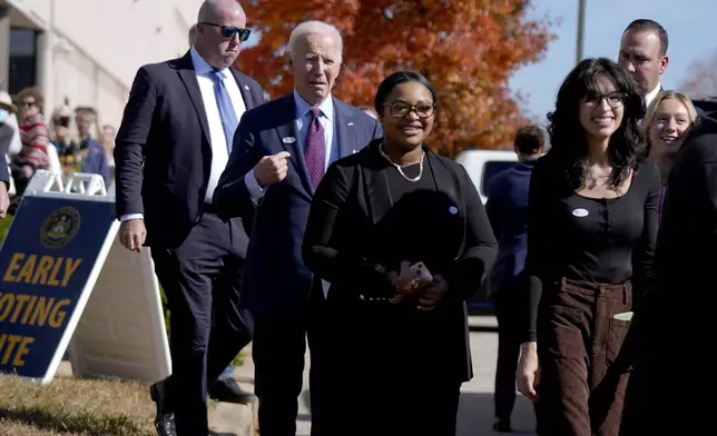 President Joe Biden, second left, departs a polling station alongside first-time voters after casting his early-voting ballot for the 2024 general elections, Monday, Oct. 28, 2024, in New Castle, Del. (AP Photo/Manuel Balce Ceneta)