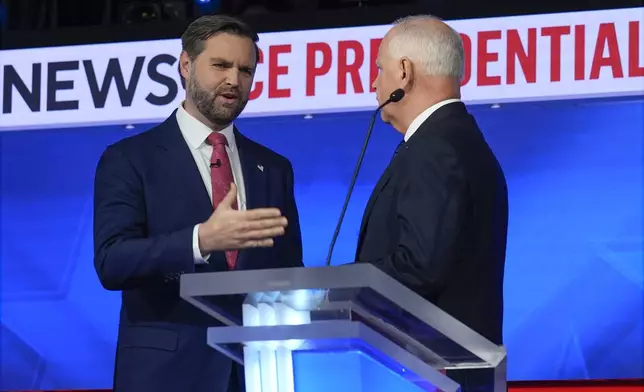 Republican vice presidential nominee Sen. JD Vance, R-Ohio, talks with Democratic vice presidential candidate Minnesota Gov. Tim Walz after the vice presidential debate hosted by CBS News Tuesday, Oct. 1, 2024, in New York. (AP Photo/Matt Rourke)