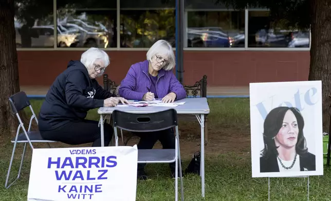 Ellen Shrum and Jeanette Rosenberg write postcards at IX Art Park in Charlottesville, Va., Thursday, Oct. 10, 2024. Charlottesville Democrats meet weekly to make phone calls, write postcards and send texts to get out the vote. (AP Photo/Ryan M. Kelly)