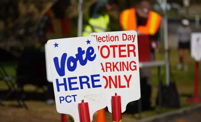 Signs direct voters to a ballot drop-off location Oct. 25, 2024, in Washington Park in Denver. (AP Photo/David Zalubowski)