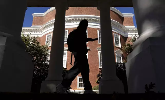 A student walks past the Rotunda at the University of Virginia in Charlottesville, Va., Friday, Oct. 11, 2024. (AP Photo/Ryan M. Kelly)