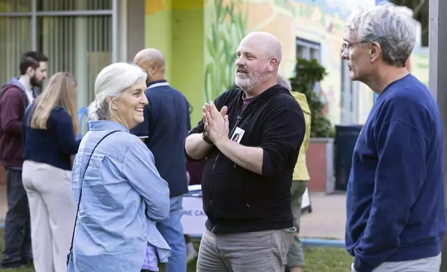 Josh Throneburg greets volunteers at IX Art Park in Charlottesville, Va., Thursday, Oct. 10, 2024. Charlottesville Democrats meet weekly to make phone calls, write postcards and send texts to get out the vote. (AP Photo/Ryan M. Kelly)