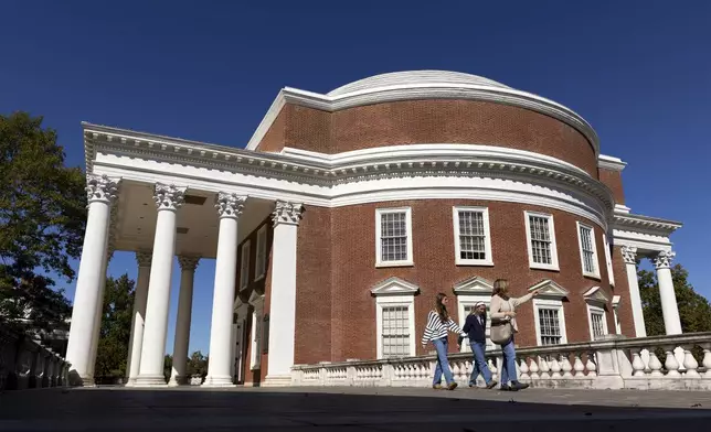 People walk past the Rotunda at the University of Virginia in Charlottesville, Va., Friday, Oct. 11, 2024. (AP Photo/Ryan M. Kelly)