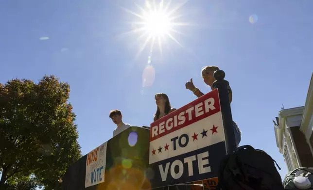 James Galvin, Ella Nelsen and Charlotte Papacosma register students to vote at the University of Virginia in Charlottesville, Va., Friday, Oct. 11, 2024. (AP Photo/Ryan M. Kelly)