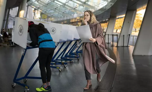 FILE - A voter moves to cast her ballot at an electronic counting machine at a polling site at the Brooklyn Museum, Nov. 8, 2022, in the Brooklyn borough of New York. ( AP Photo/John Minchillo, File)