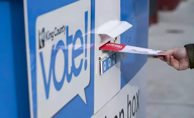 FILE - A person puts their ballot in a drop box at a library in Seattle's White Center neighborhood on Oct. 27, 2020. (AP Photo/Ted S. Warren, File)