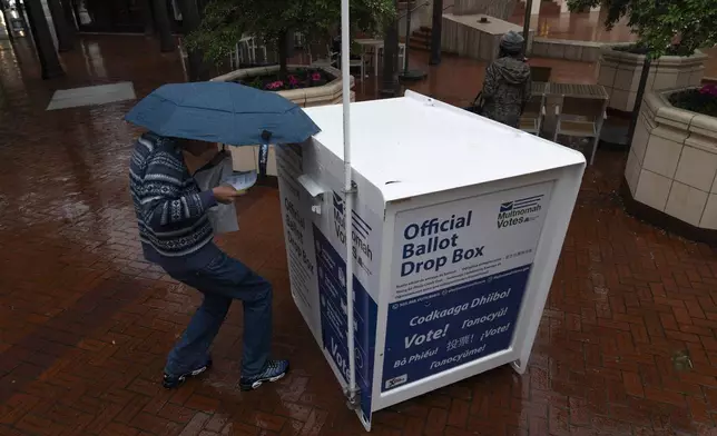 FILE - A person drops off their vote-by-mail ballot at a dropbox in Pioneer Square during primary voting on Tuesday, May 21, 2024, in Portland, Ore. (AP Photo/Jenny Kane, File)