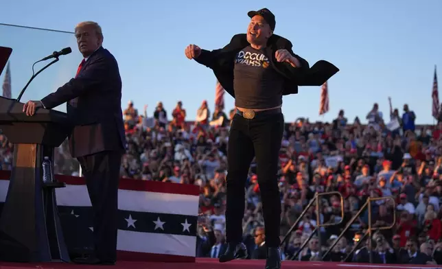 FILE - Elon Musk jumps on the stage as Republican presidential nominee former President Donald Trump speaks at a campaign rally at the Butler Farm Show, Saturday, Oct. 5, 2024, in Butler, Pa. (AP Photo/Evan Vucci, File)