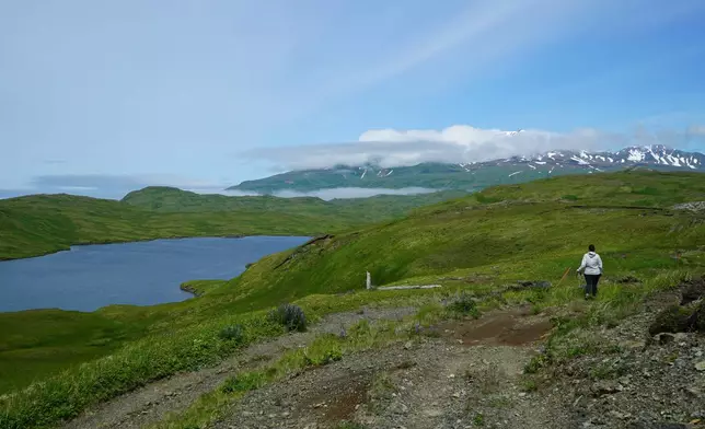 FILE - This July 8, 2021, photograph shows a hiker en route to Lake Bonnie Rose, one of many scenic hiking options on Adak Island, Alaska. (Nicole Evatt via AP, File)