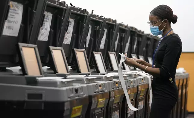 FILE - An employee at the Broward Supervisor of Elections Office conducts logic and accuracy testing of equipment used for counting ballots, Thursday, Sept. 24, 2020, in Lauderhill, Fla. (AP Photo/Lynne Sladky, File)