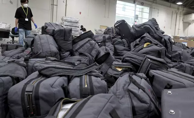 FILE - A worker prepares to take bags of ballots to be sorted and processed by the Los Angeles County Registrar at the temporary building at the Pomona Fairplex in Pomona, Calif., Thursday, Nov. 5, 2020. (Keith Birmingham/The Orange County Register via AP)