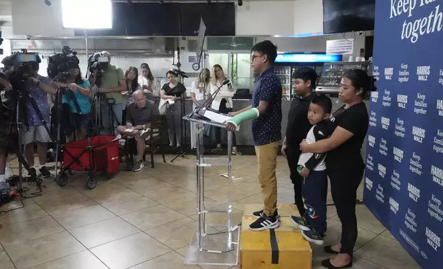 FILE- Hamilton, no last name given, stands next to his family during a Democratic Party campaign event where he spoke of his experience on being separated from his mother when their crossed the U.S-Mexico border during the Trump administration, Oct. 16, 2024, in Doral, Fla. (AP Photo/Marta Lavandier, File)