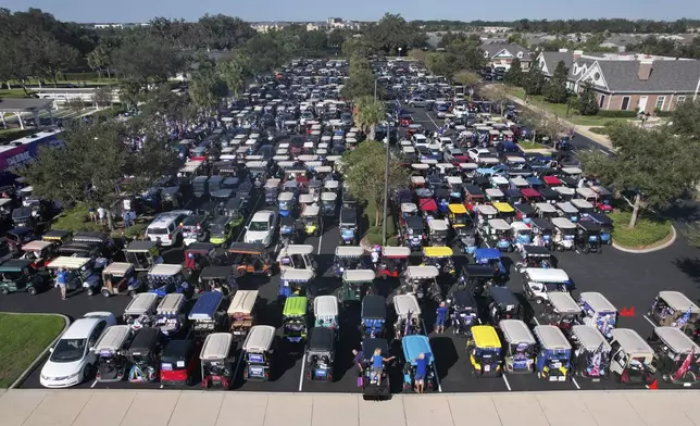 Hundreds of supporters of Democratic presidential nominee Vice President Kamala Harris prepare to participate in a golf cart parade to deliver their completed mail-in ballots, in The Villages, Fla., Monday, Oct. 14, 2024. The Villages, one of the world's largest retirement communities, has long been known as a conservative stronghold, but Democrats energized by Harris' candidacy have quietly become more visible. (AP Photo/Rebecca Blackwell)