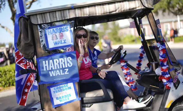 Former Rep. Debbie Mucarsel-Powell of Florida, center, now a Democratic candidate for the U.S. Senate, waves from a cart as she joins hundreds of supporters of Democratic presidential nominee Vice President Kamala Harris in a golf cart parade to deliver their completed mail-in ballots, in The Villages, Fla., Monday, Oct. 14, 2024. The Villages, one of the world's largest retirement communities, has long been known as a conservative stronghold, but Democrats energized by Harris' candidacy have quietly become more visible. (AP Photo/Rebecca Blackwell)